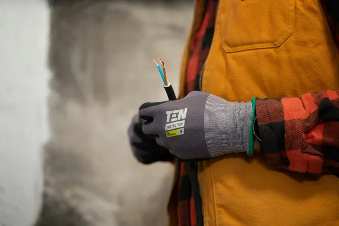 Electrician's gloved hands holding wiring